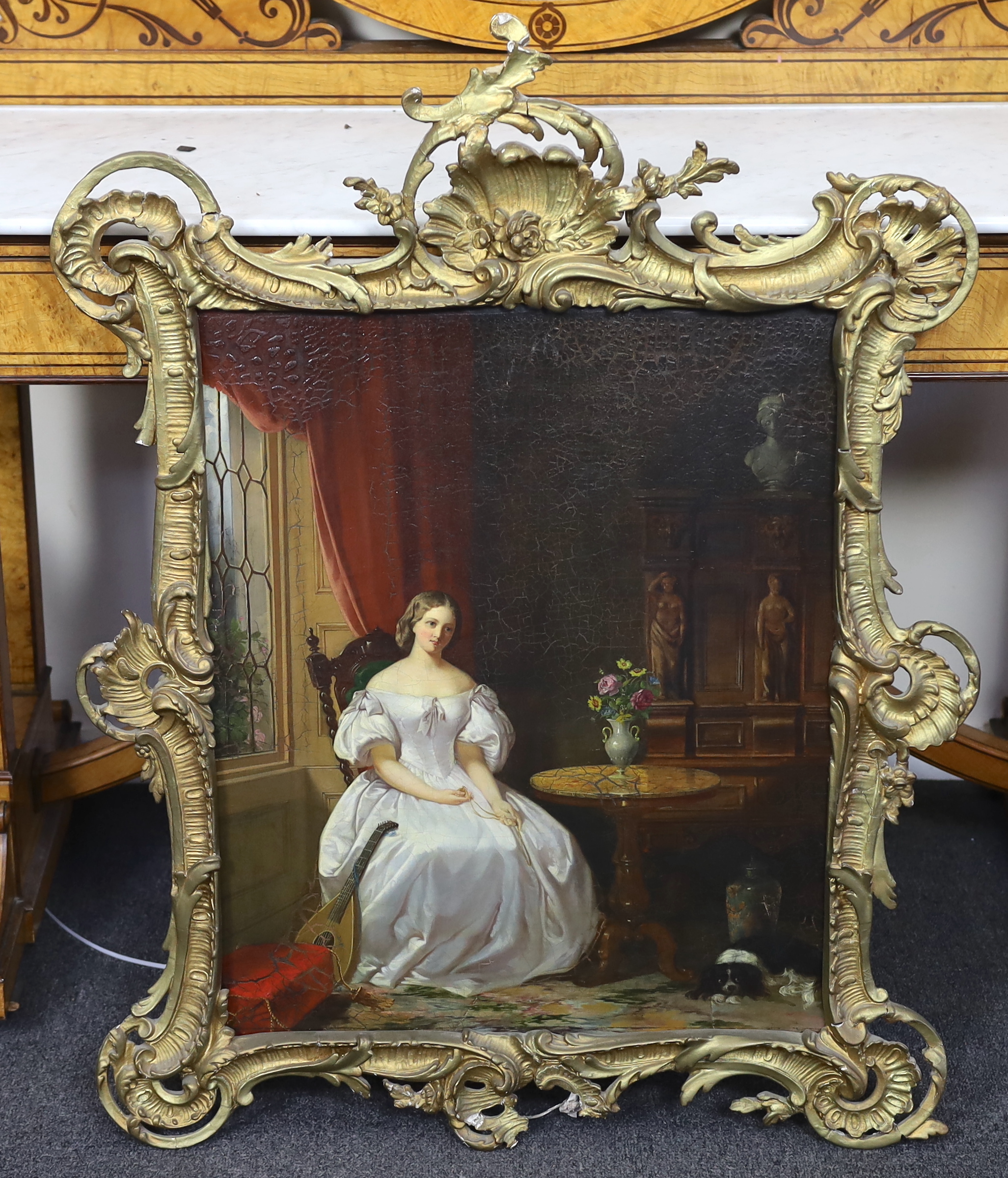 19th century English School , Interior with seated lady holding a pendant on chain, a spaniel at her feet, oil on canvas, 60 x 50cm